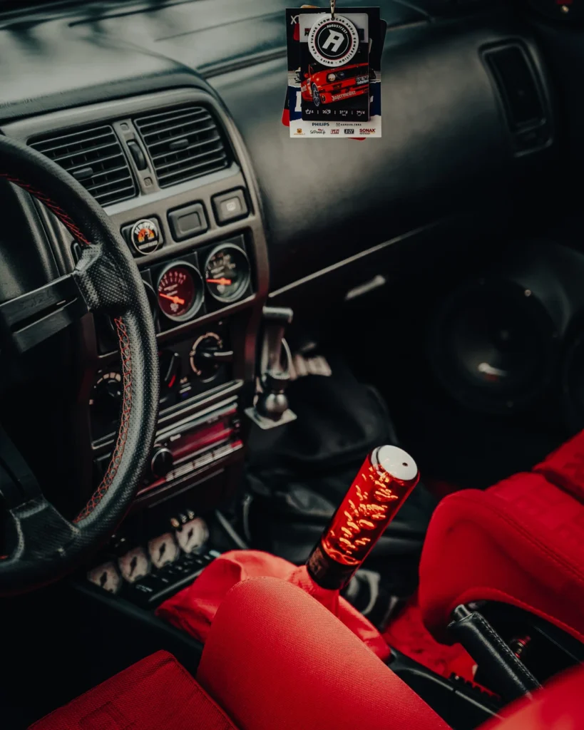 Modified car interior with red seats, extra gauges and a long red lever.