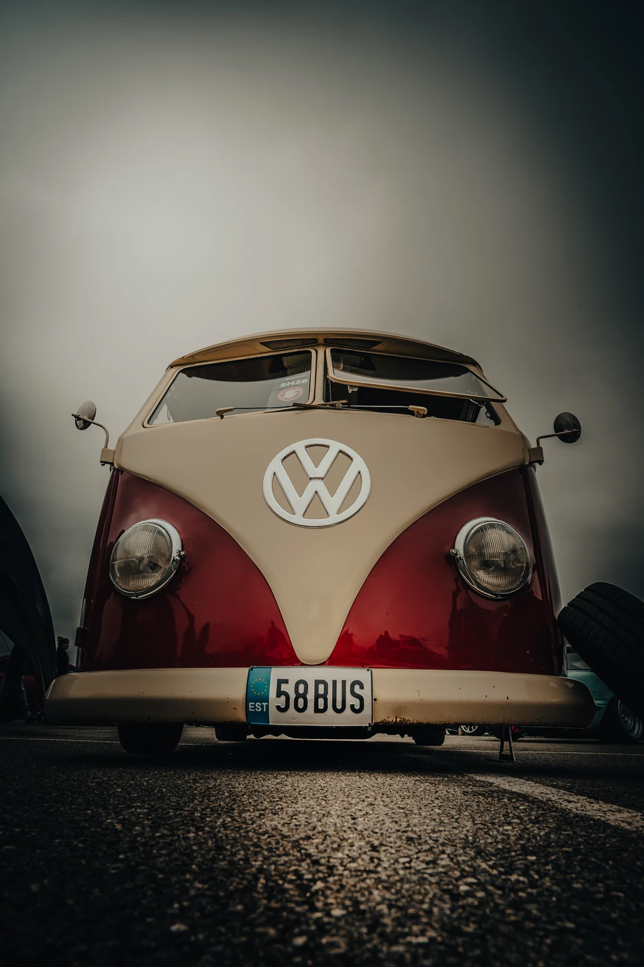 Classic red and beige Volkswagen bus front view at Augustfest 2025.