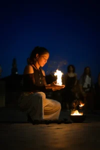 Fire performer holding flames at dusk.