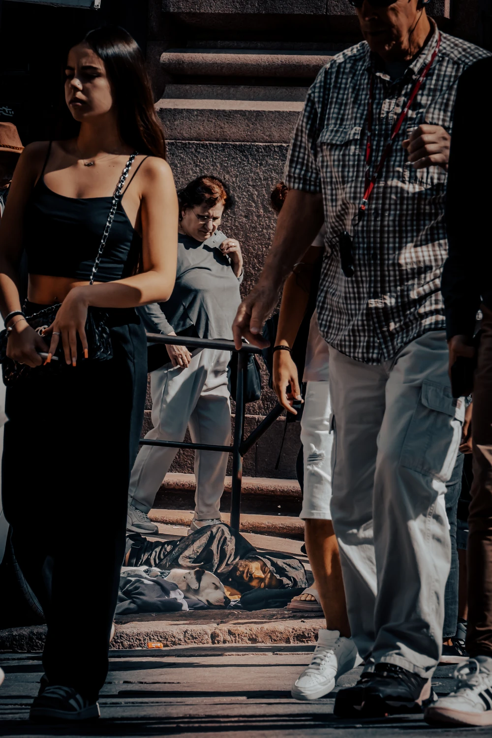 Street scene with pedestrians walking through strong light.