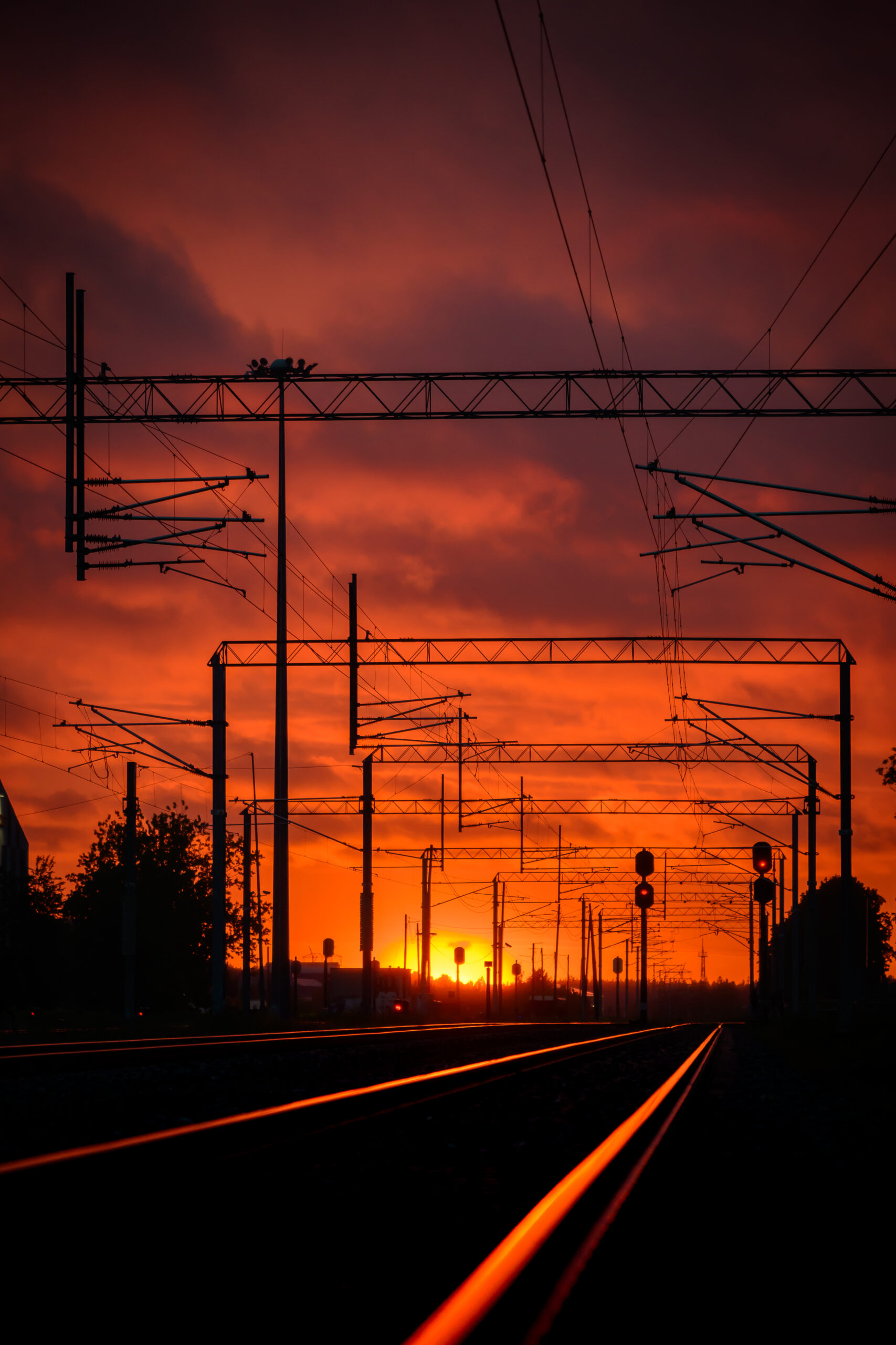 Railway tracks leading into an orange sunset.