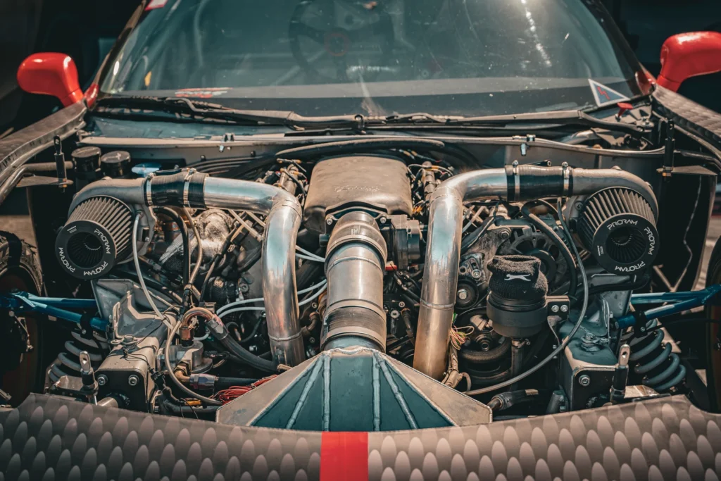Front view of an exposed engine bay with a round air filter and metal pipes on each side.