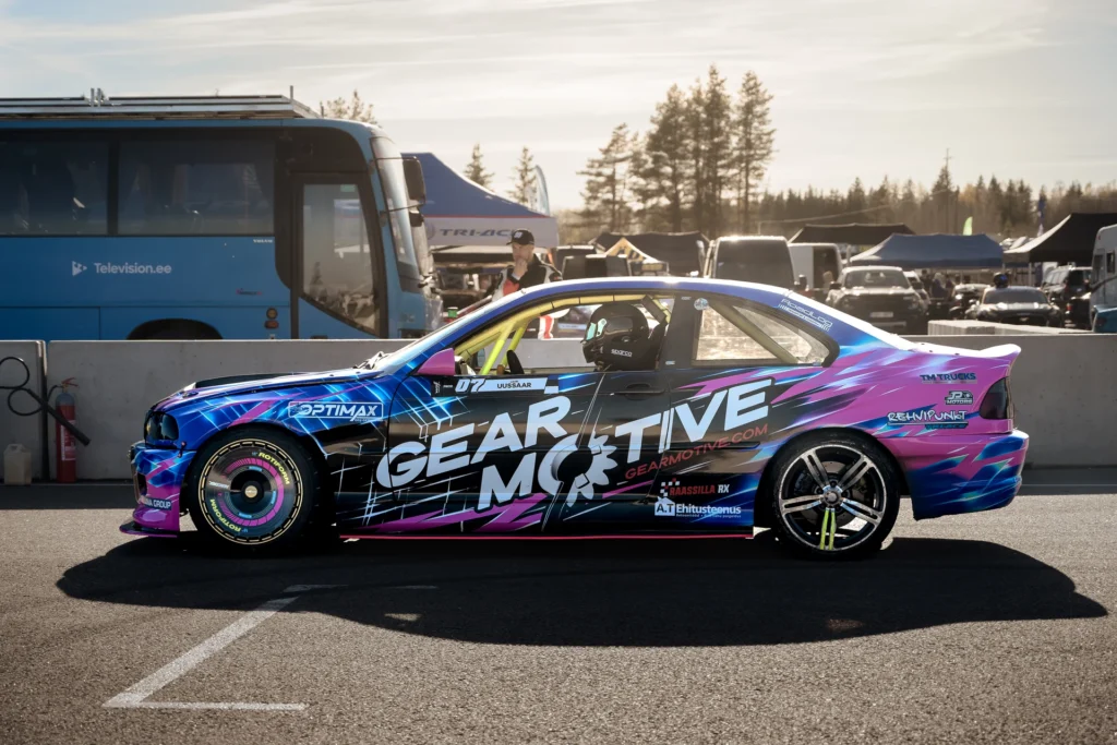 Side view of a blue-and-purple drift car with a bright-yellow roll cage visible through the window.