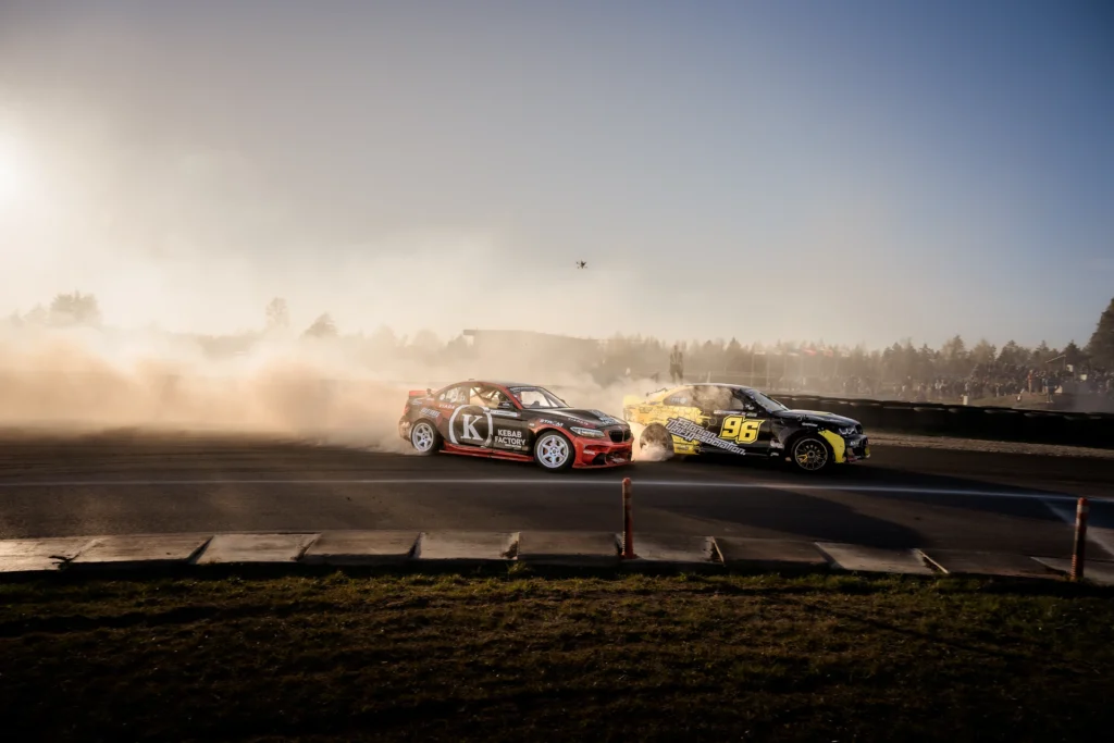A red drift car follows a yellow-and-black car carrying number 96.