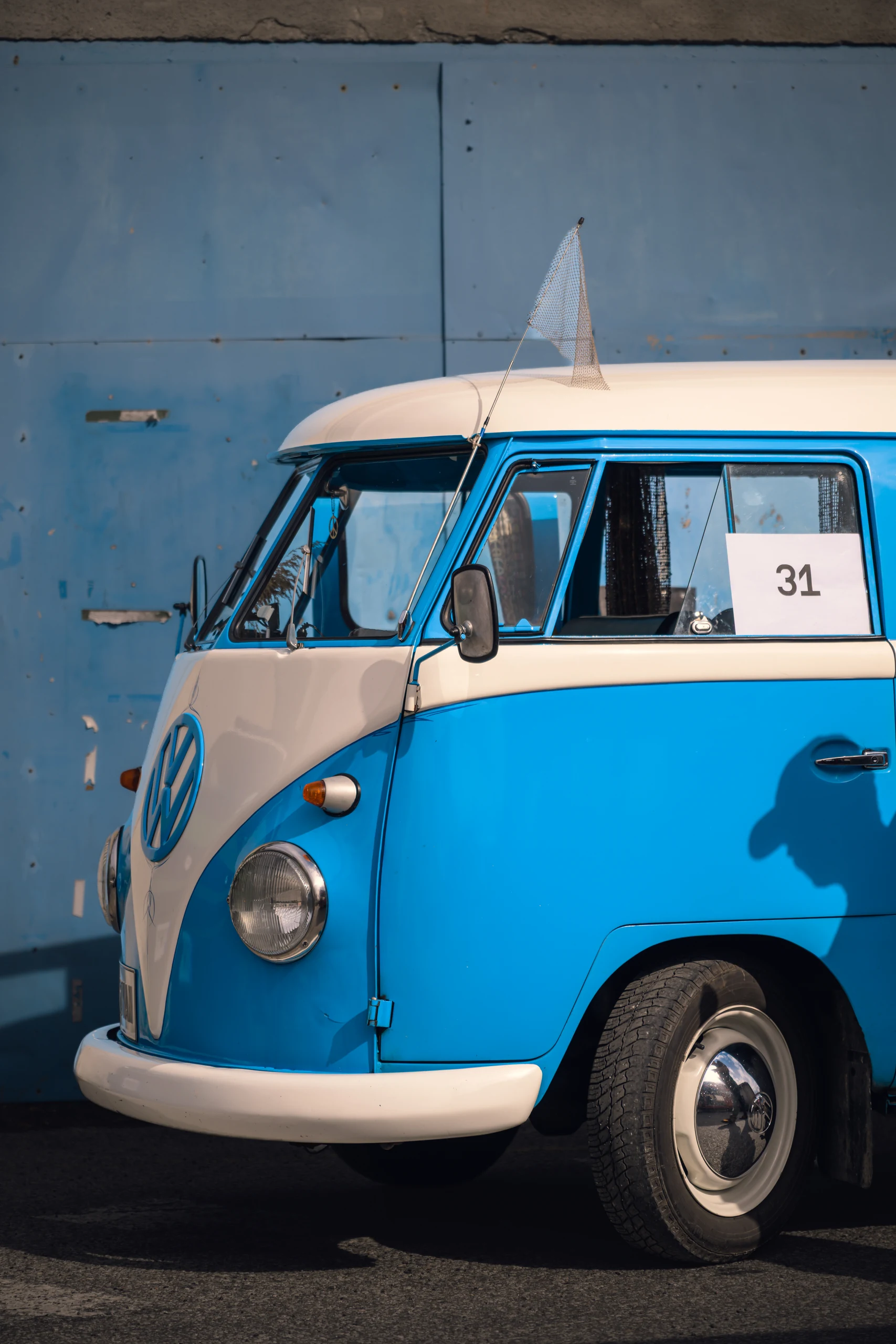 Sinivalge Volkswageni matkabuss Põhjala tehase suure sinise ukse ees.