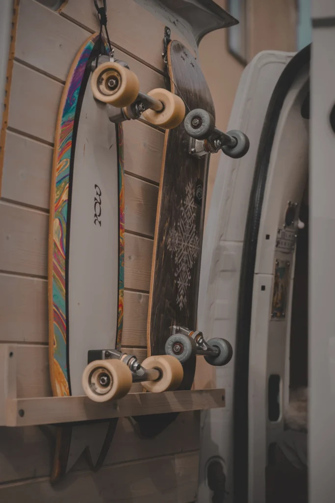 Close view of two skateboards mounted vertically on a door, their large wheels facing into the van.