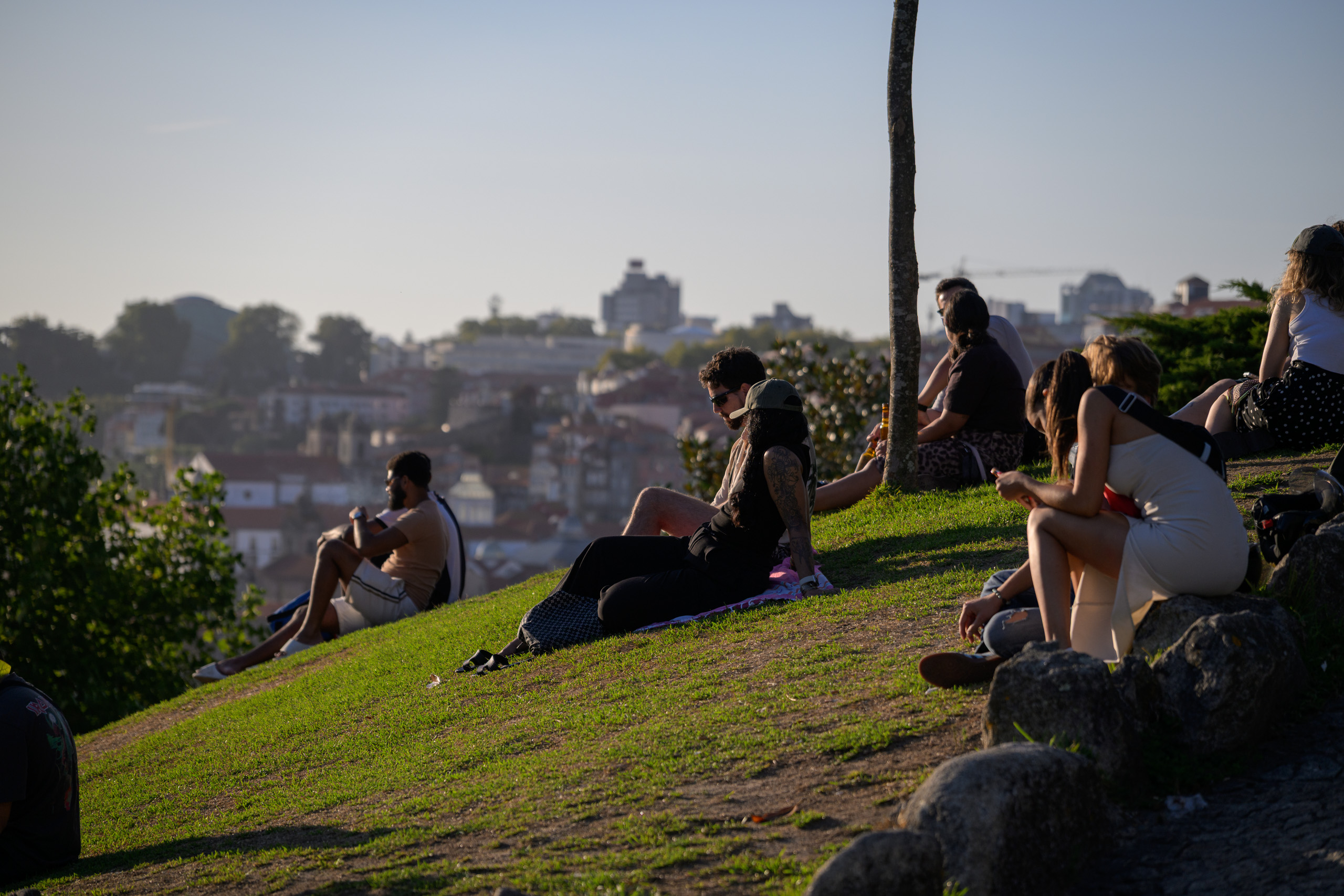 With preset. People on the green Jardim do Morro hillside in warm evening light — with the Documentary Natural preset.