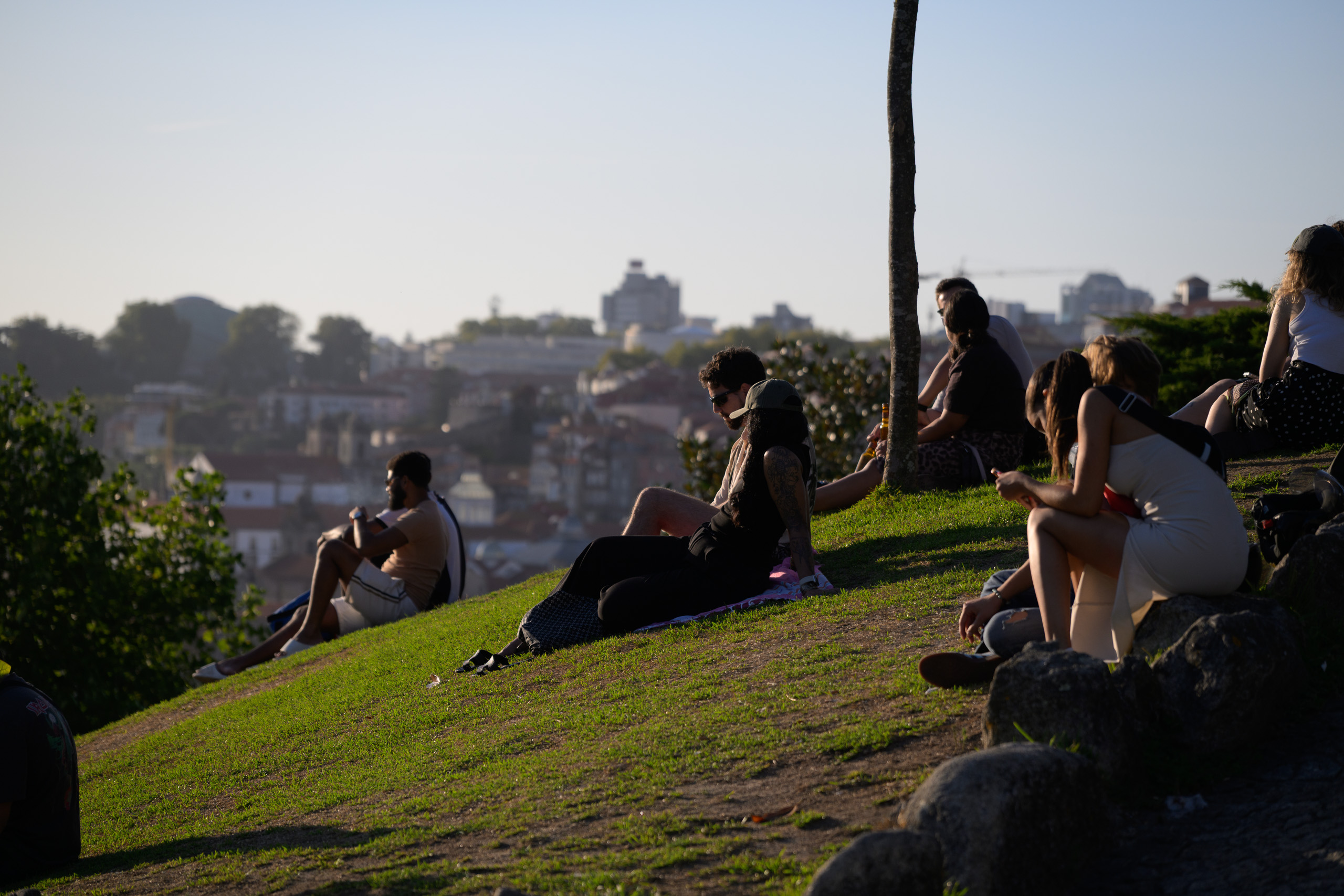 Before. People on a green evening hillside, bright edges and deeper shadows — before applying the preset.