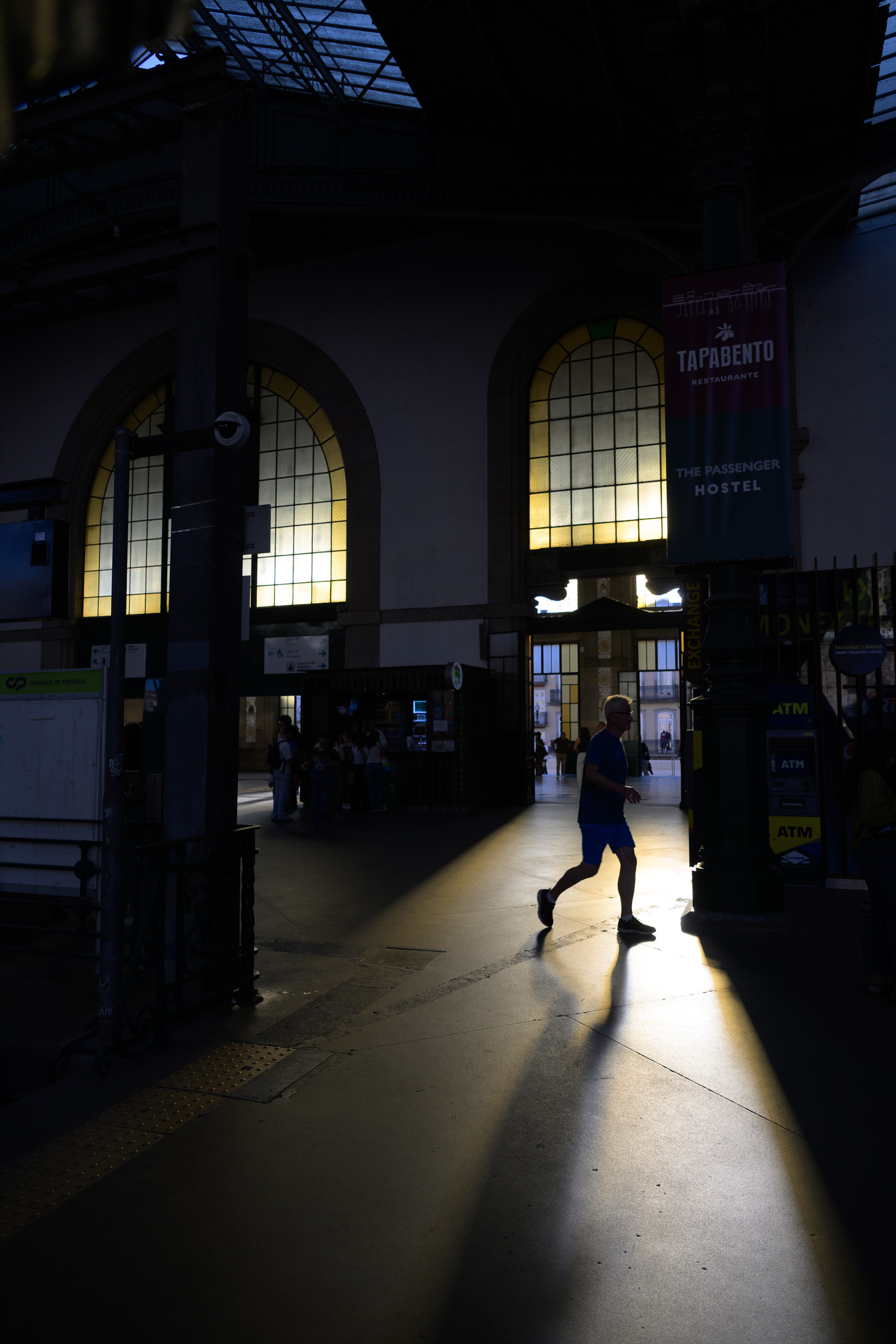Before. Human silhouette in window light inside São Bento station — before applying the preset.