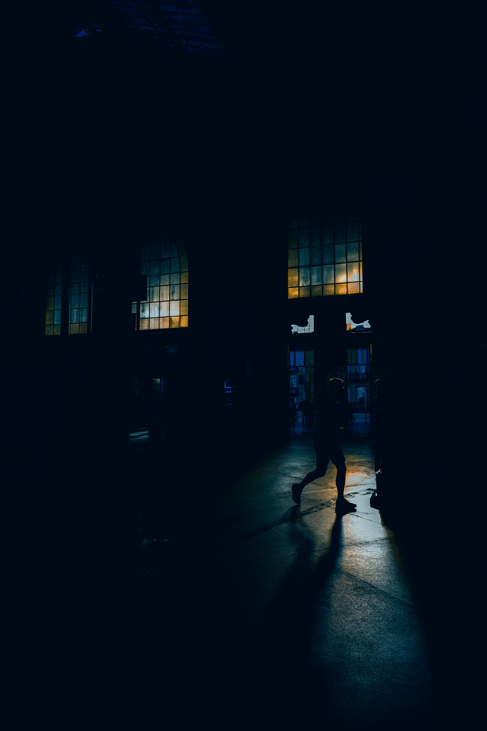 With preset. Human silhouette in window light inside São Bento station — with the Sun Slice Noir preset.