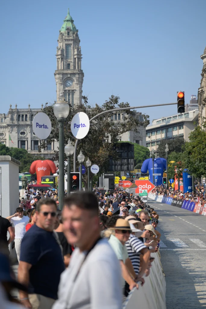Spectators line the race route in Porto beneath the city hall tower.