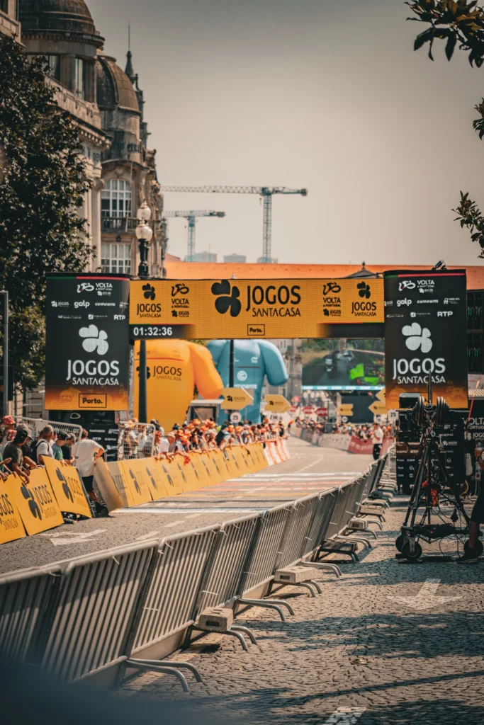 The fenced finishing straight and yellow race arch between historic buildings in Porto.