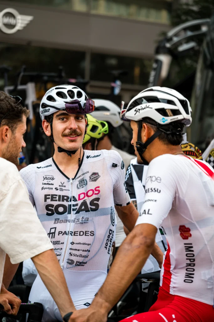 Cyclists in white racing jerseys talk beside the bicycles after the race.