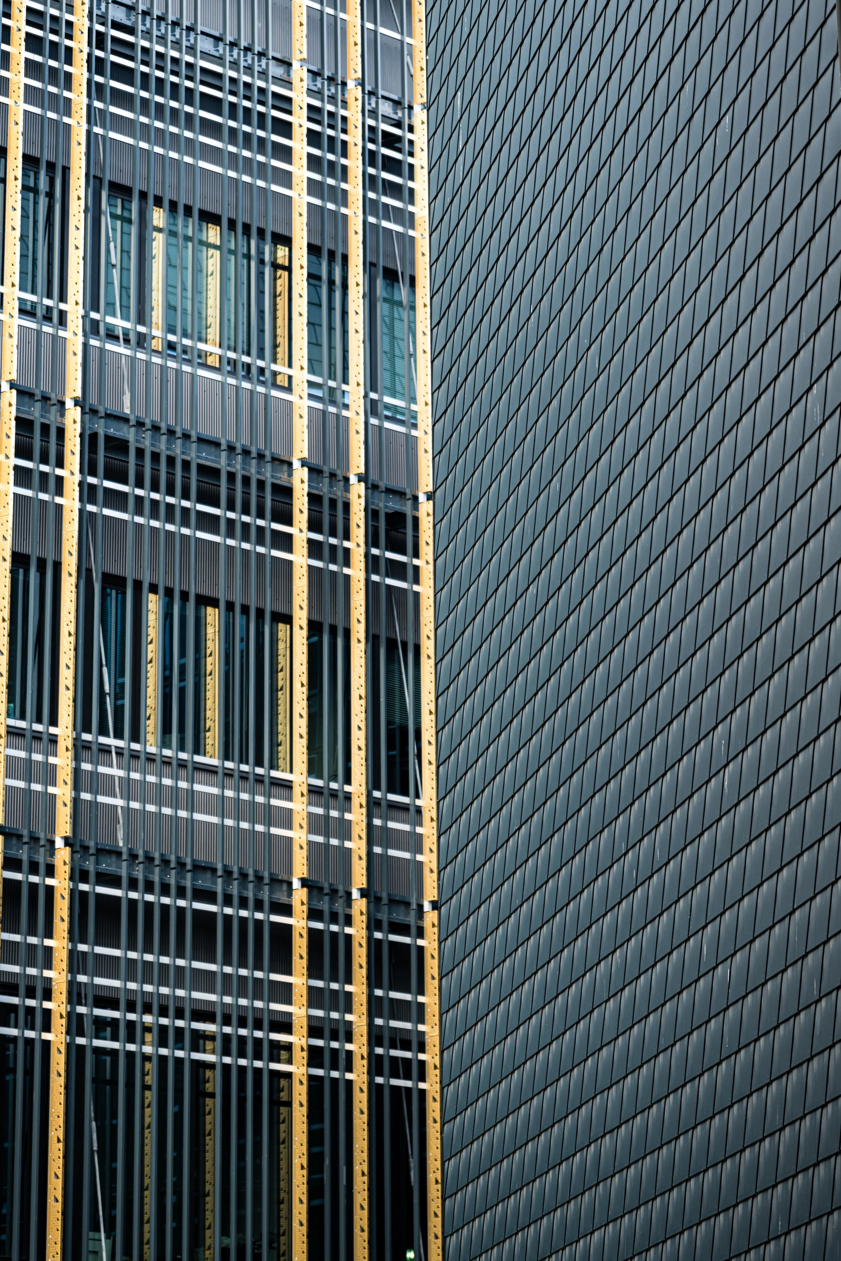Golden and grey facade fins at the Delta Centre beside the geometric pattern of grey wall panels.